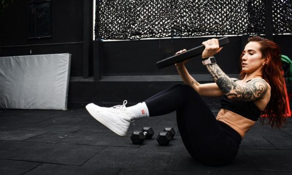 A determined woman performs a core workout in an indoor gym setting.